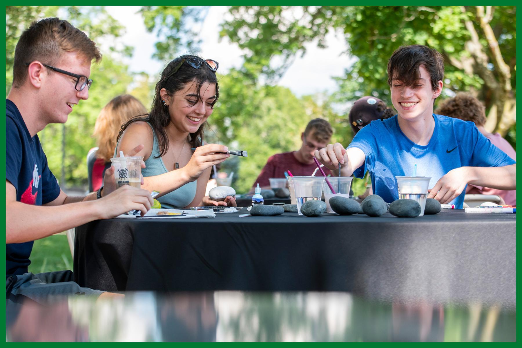 Students laughing and painting rocks